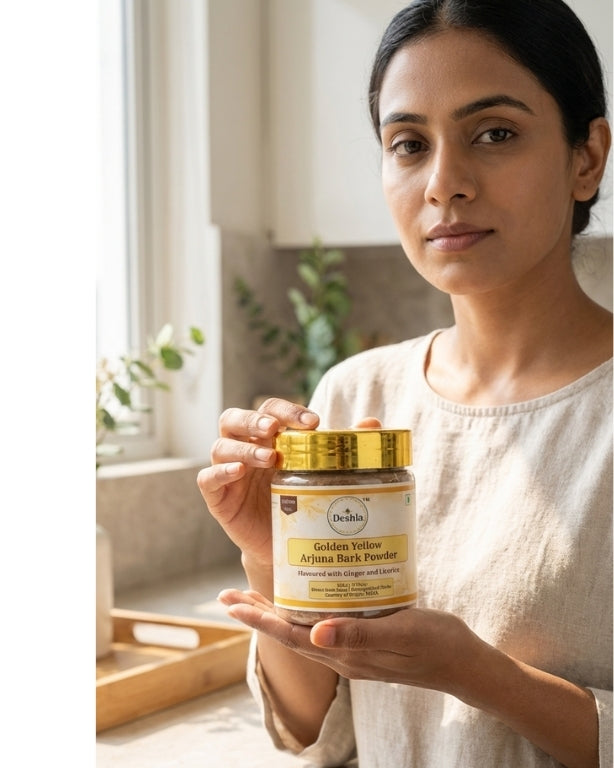 Woman holding a jar of Dabur Golden Yellow Arjuna Bark Powder in a kitchen setting.