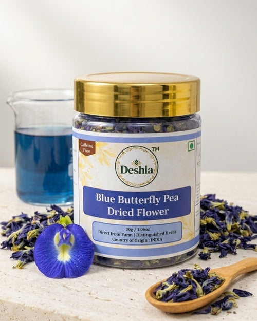 Jar of Deshla Blue Butterfly Pea Dried Flower with a spoonful of flowers and a blue butterfly pea flower on a white background.