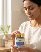 Woman holding a container of Doshin Blue Butterfly Pea product in a home setting.