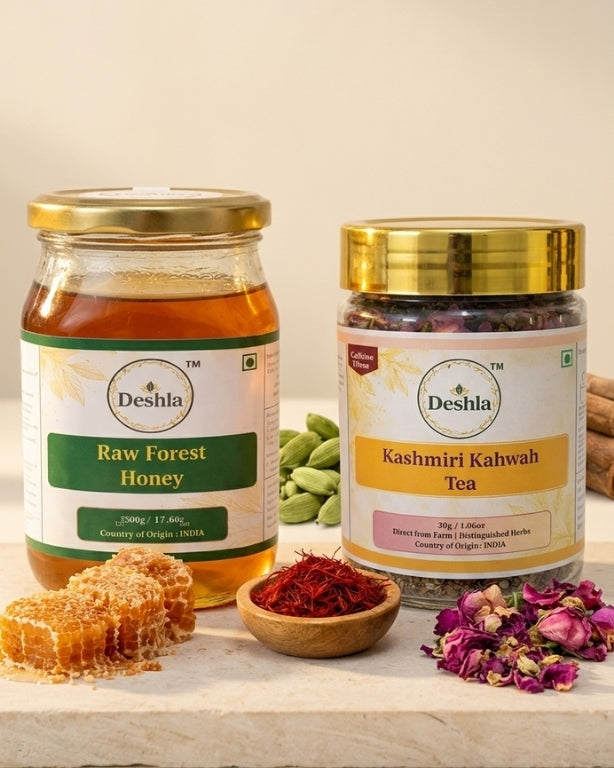Two jars of Deshla honey and tea on a wooden surface with honeycomb and tea leaves.