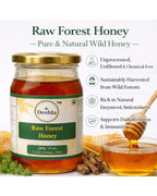 Jar of Deshla Raw Forest Honey with honey dipper and bowl on a white background