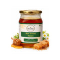 Jar of Deshla Raw Forest Honey with honeycomb and flowers on a white background